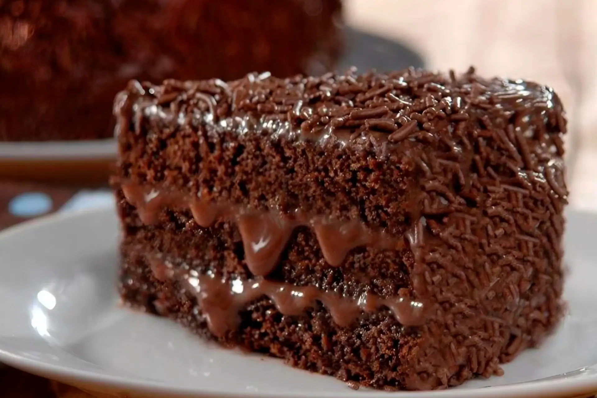 Fatia de bolo de chocolate com recheio e granulado por cima