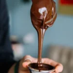 Concha derramando calda de chocolate em potinho de vidro