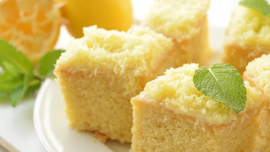 Fatias quadradas de bolo de limão siciliano com folha de hortelã vista de muito perto