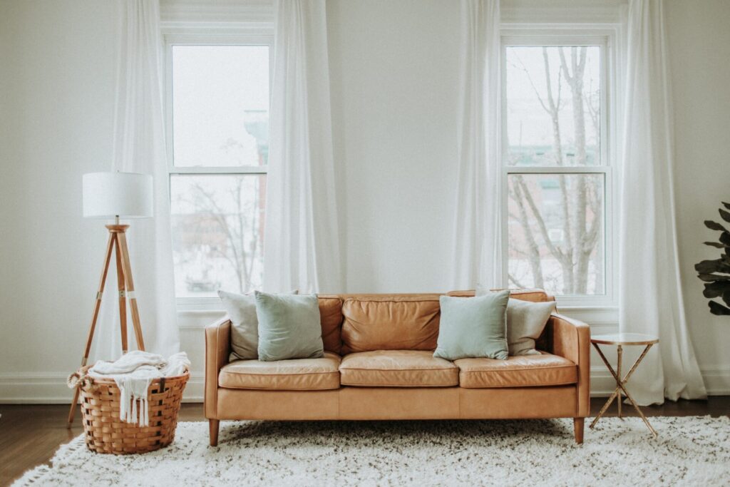 Sofá, cortinas, tapetes e almofadas em harmonia com uma sala com decoração