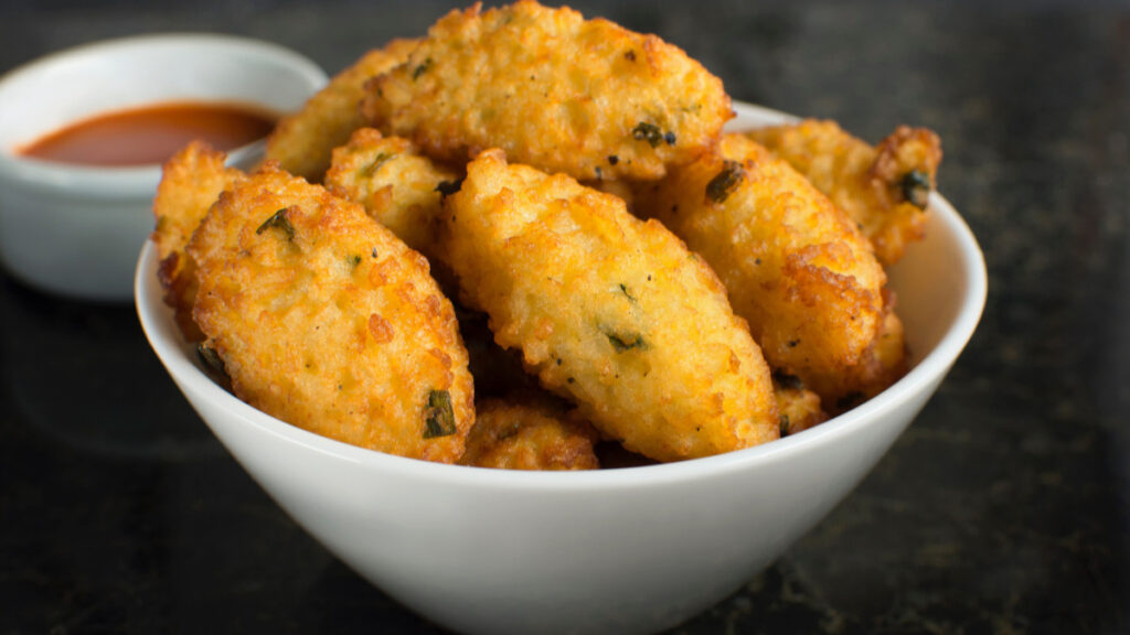 Bolinho de arroz frito dentro de recipiente branco de vidro