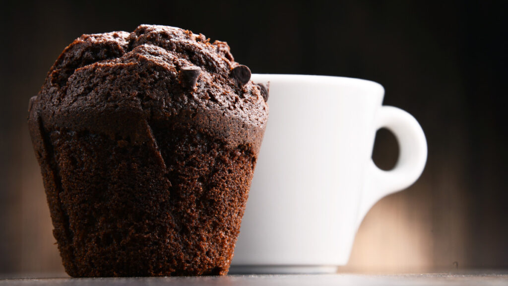 Brownie de caneca em primeiro plano e uma caneca branca no plano de fundo