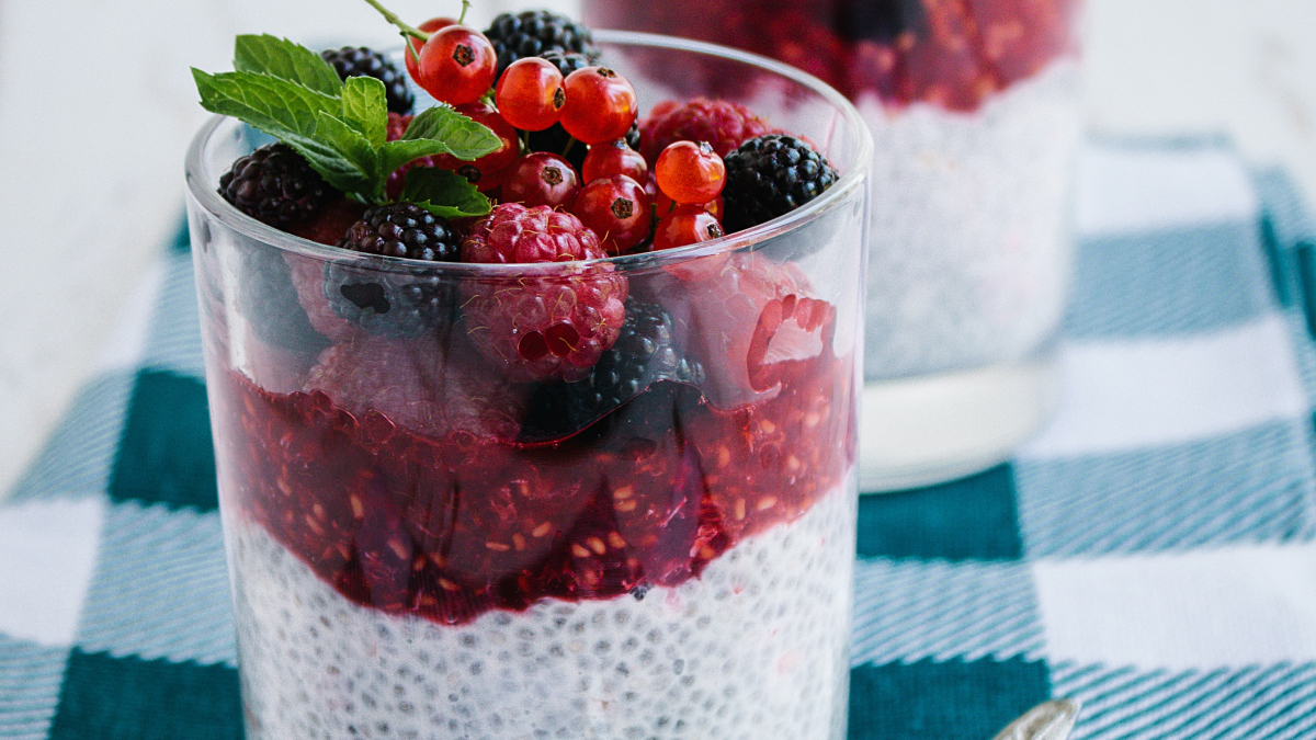 Pudim de chia em copo de vidro com frutas vermelhas por cima