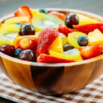 Salada de frutas em bowl redondo em cima de uma toalha xadrez