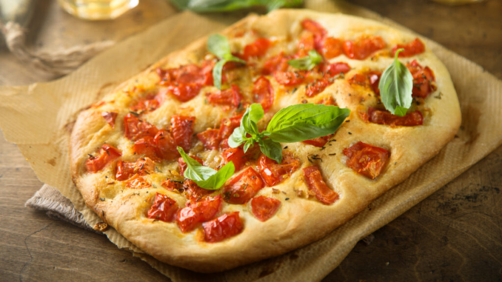 Focaccia de pizza em cima de mesa de madeira