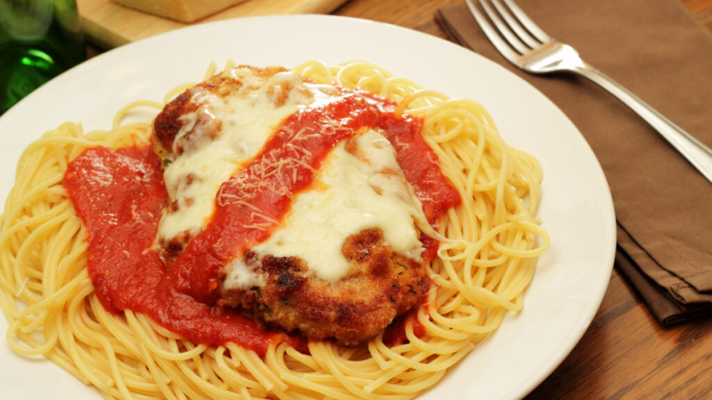 Prato de frango a parmegiana com molho de tomate e macarrão