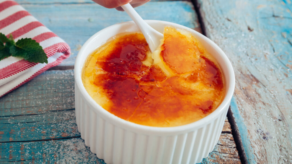 Crème brûlée maçaricado e caramelizado em recipiente de vidro branco