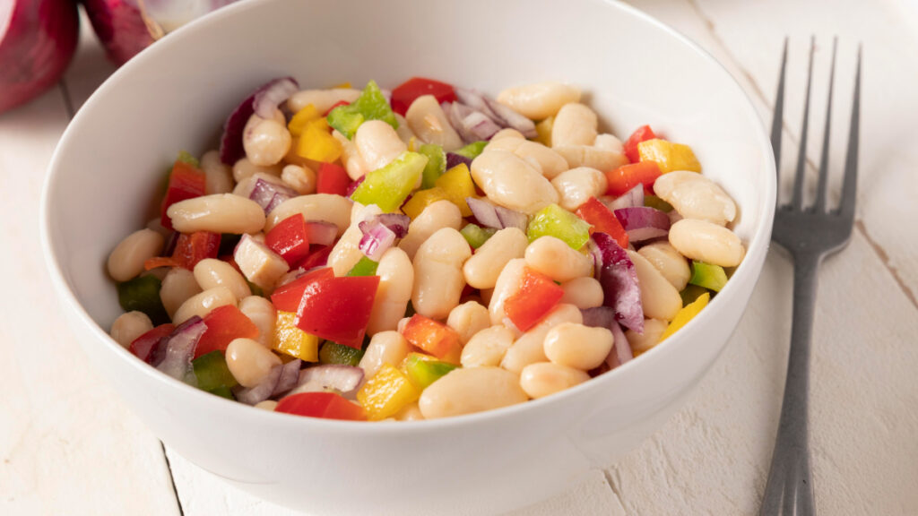 Salada de grão de bico em bowl branco com tomates e pimentões picados