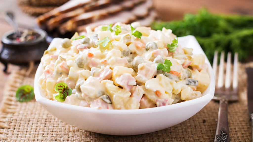 Salada de maionese vista de lado em travessa branca