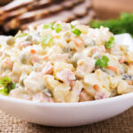 Salada de maionese vista de lado em travessa branca