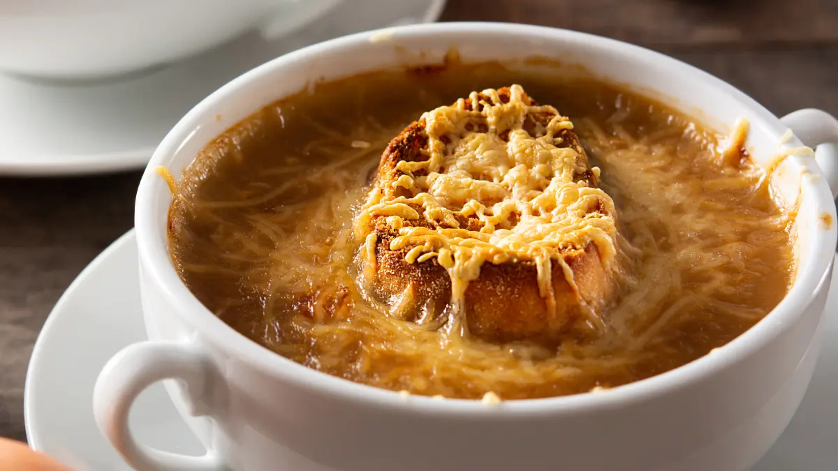 Sopa de cebola finalizada com pão e queijo por cima