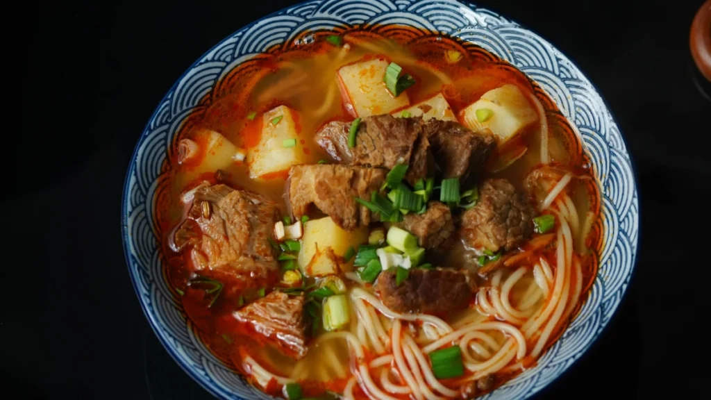 Sopa de carne em prato azul visto de cima