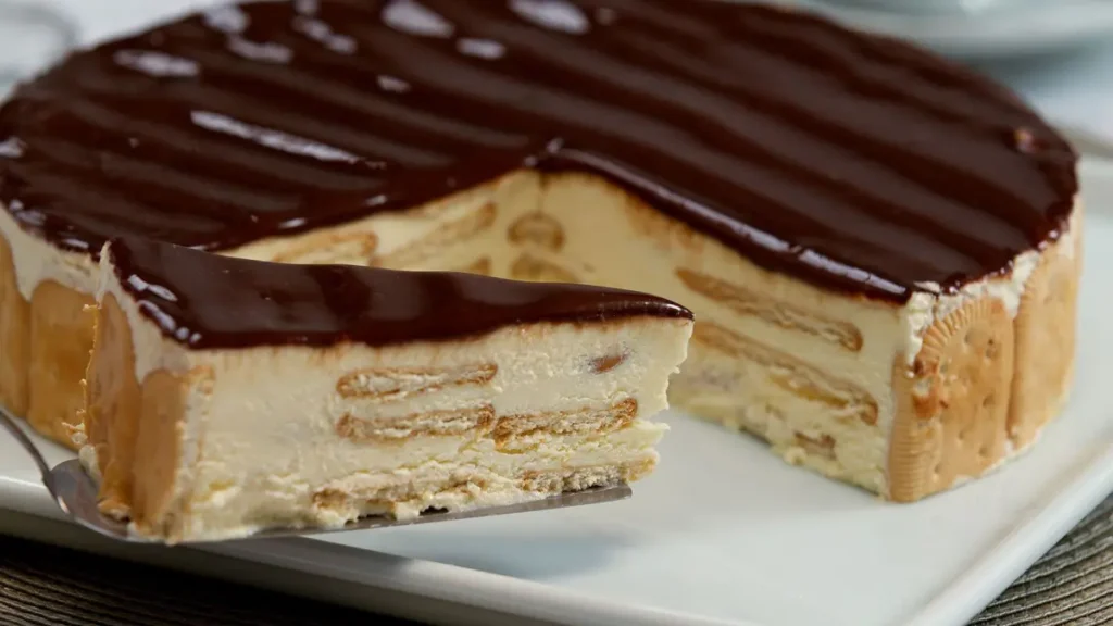 Fatia de torta alemã em cima de espátula com a torta alemã ao fundo