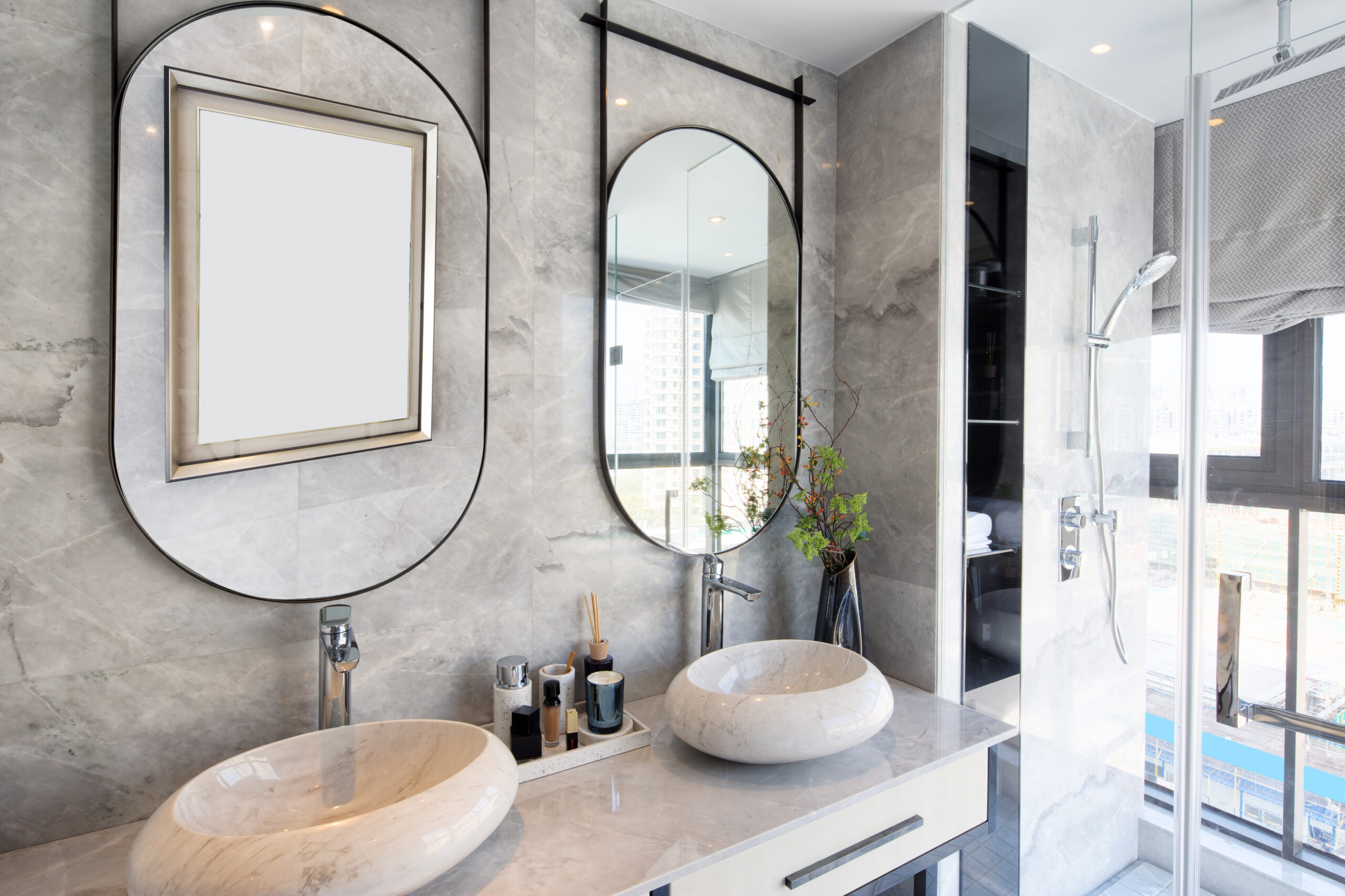 Banheiro elegante em tons marmorizados, espelho em metalon e cubas esculpidas