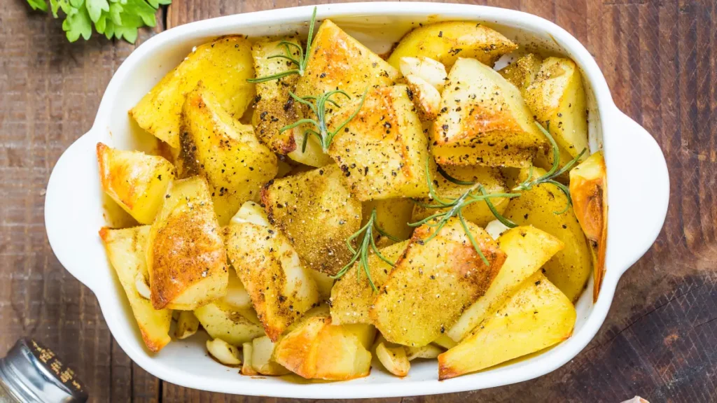 Bacalhau com batata visto de cima servido em travessa branca de vidro