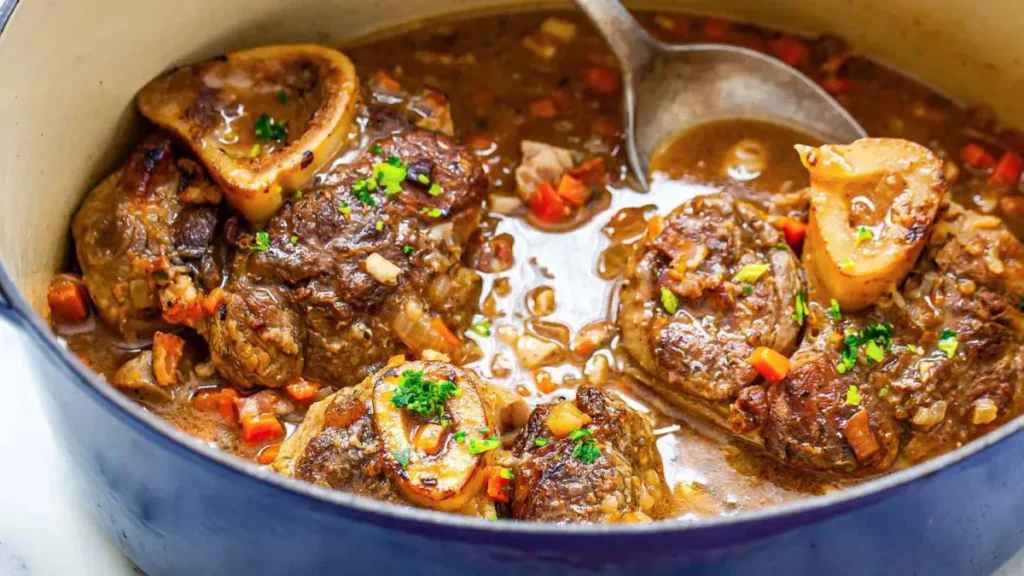 Ossobuco servido em panela azul com colher de inox dentro