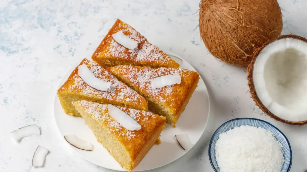 Fatias de bolo de coco cremoso com coco ralado por cima