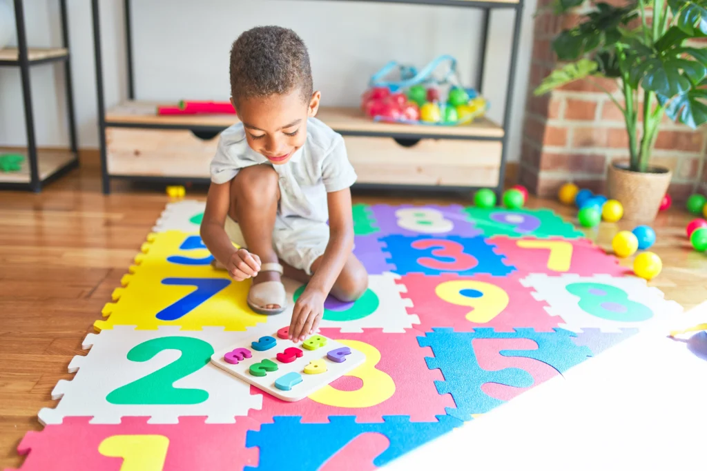 criança brincando em tapete de atividades colorido