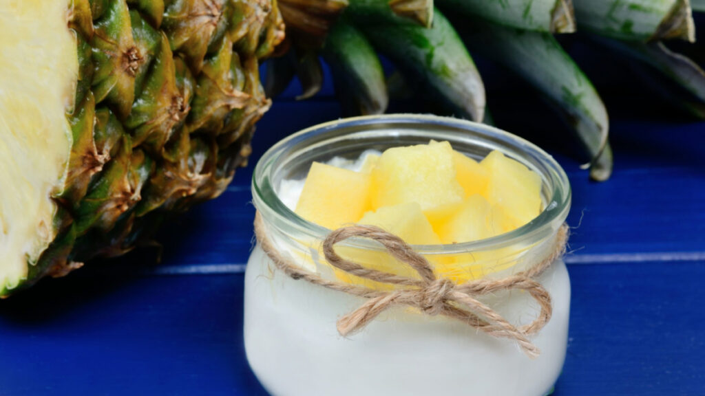 Mousse de abacaxi em pote de vidro individual com cubos de abacaxi freco por cima