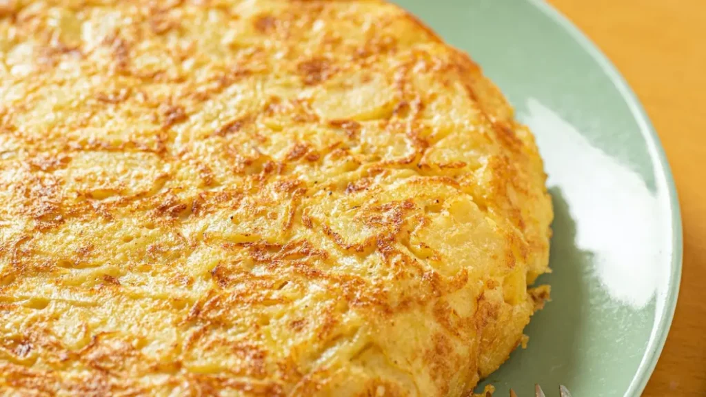 Pão de queijo de frigideira servido em prato de louça verde