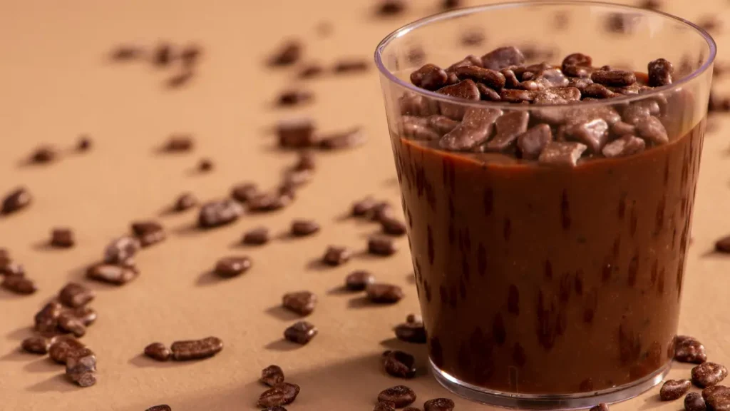 Brigadeiro de microondas em potinho de acrílico com granulados ao fundo