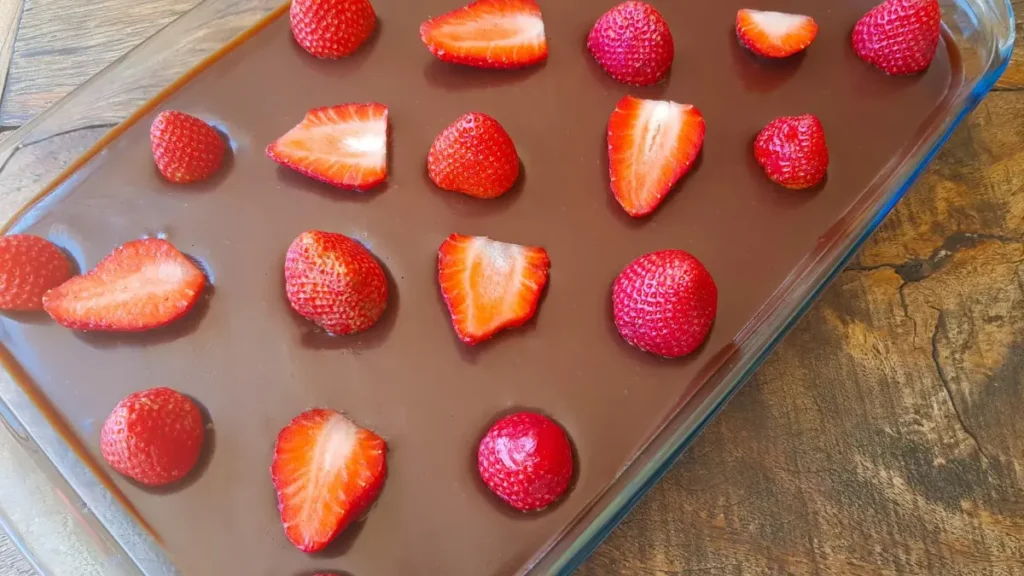 Pavê de morango visto de cima com camada de chocolate e morangos fatiados