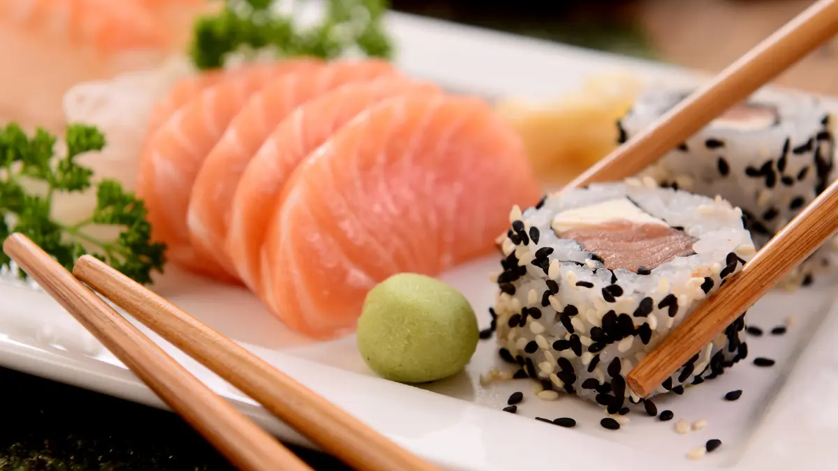 Prato de sushi feito em casa com uramaki e sashimi de salmão e pasta de gengibre