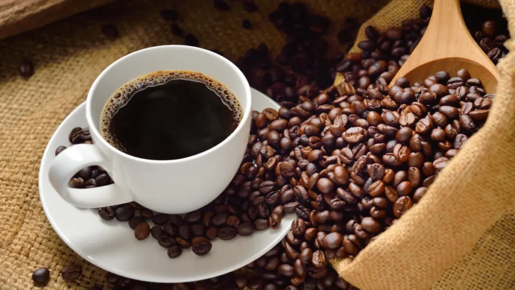 Como fazer café preto em xícara branca com grãos caídos ao lado