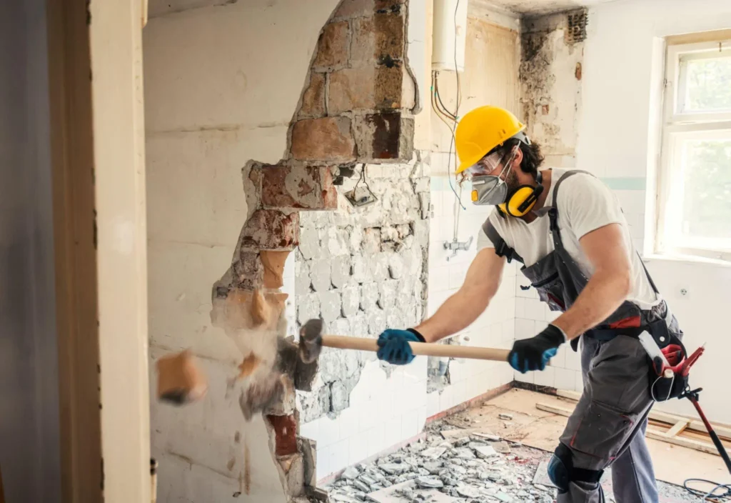 Homem quebrando paredes em casa para reforma