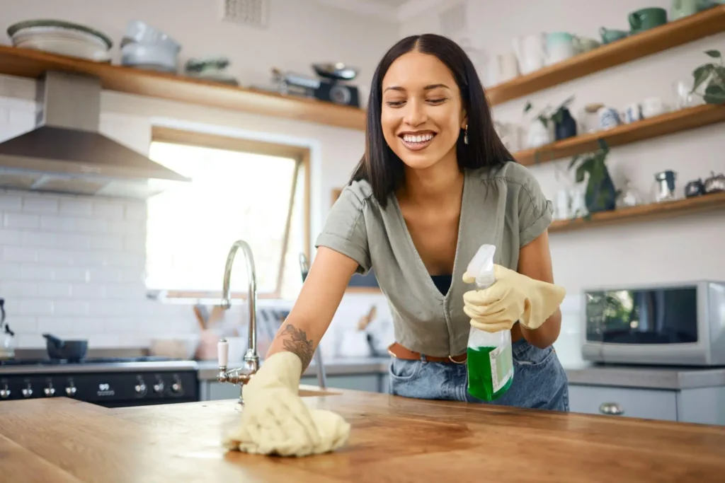 Mulher limpando bancada de madeira em uma cozinha