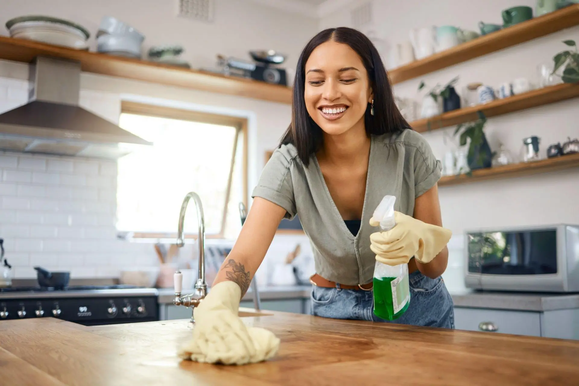 Mulher limpando bancada de madeira em uma cozinha