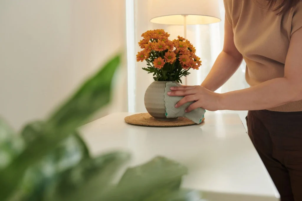 Mulher limpando um vaso decorativo