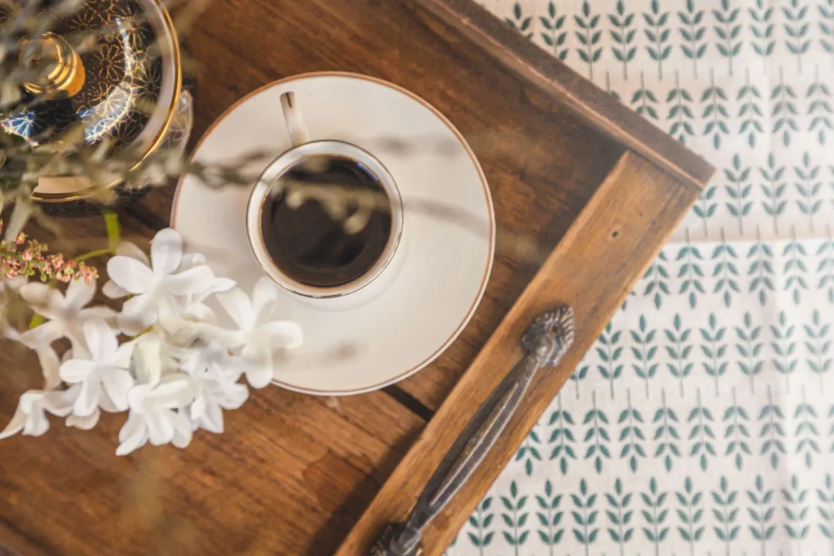 Cantinho do café em uma bandeja de madeira com flores e decoração