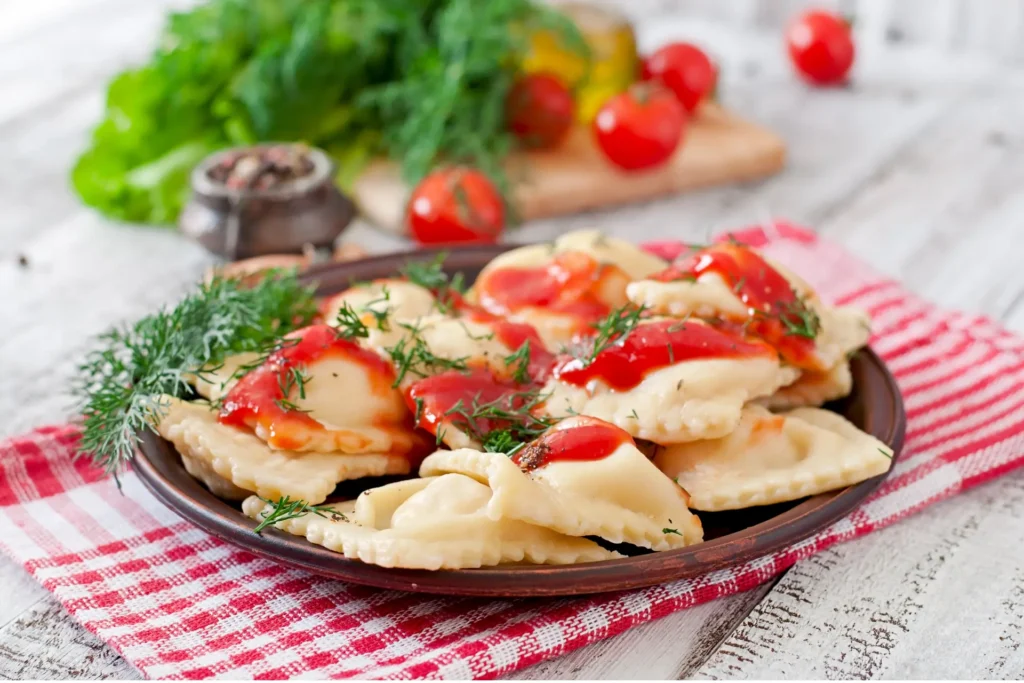 Um prato de ravioli com molho de tomate.