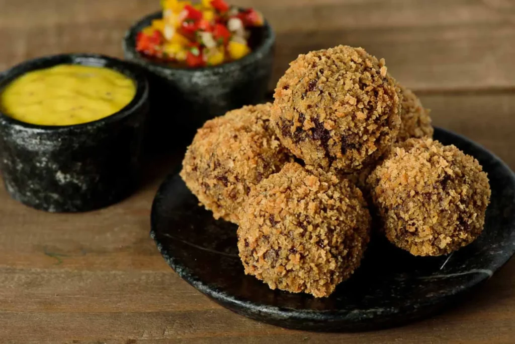 Croquete de costela servido em potes pretos.