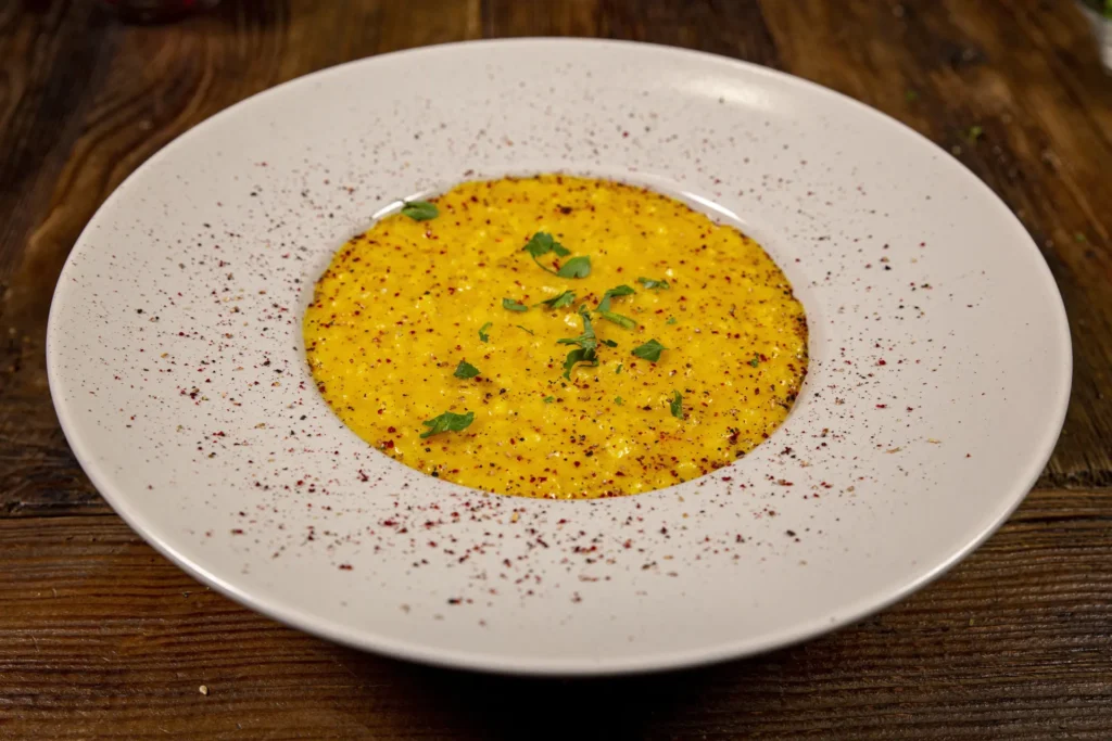 Risoto de açafrão servido em prato fundo.