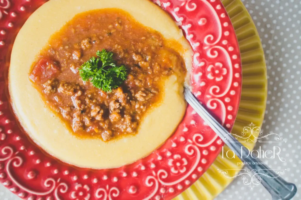 Angu com fubá servido em prato com carne moída.